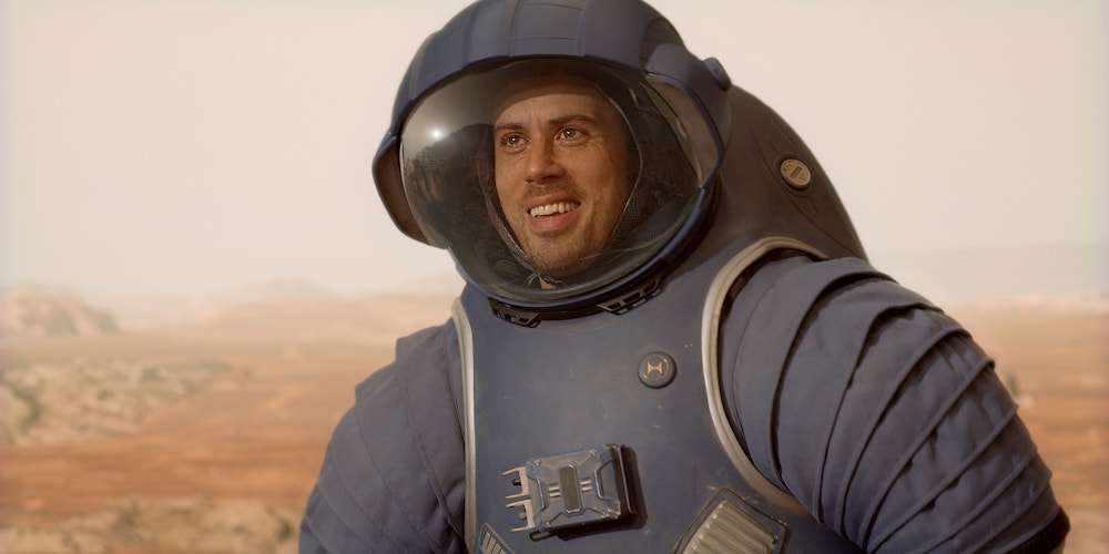 'For All Mankind' Season 4, shows a man in a blue spacesuit, smiling, on the surface of Mars