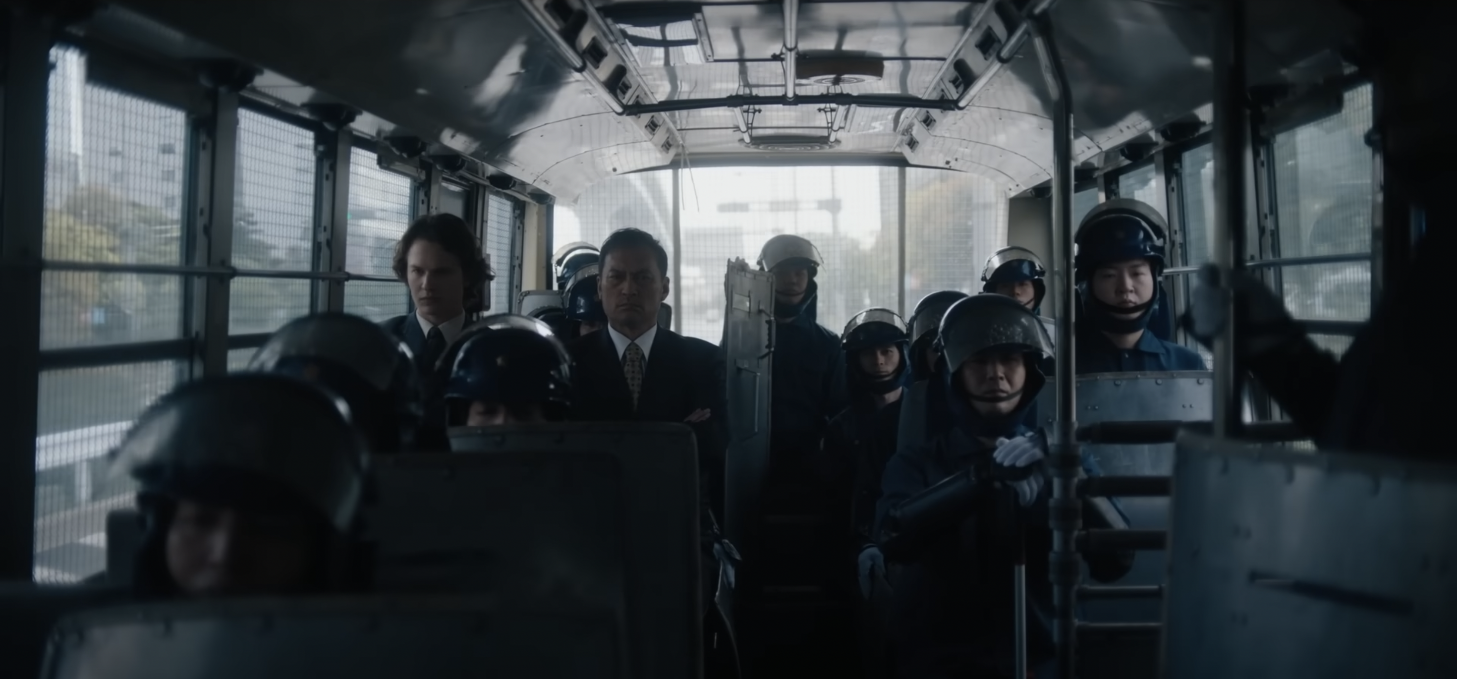 Two men and a team in secure gear on a bus; still from 'Tokyo Vice'